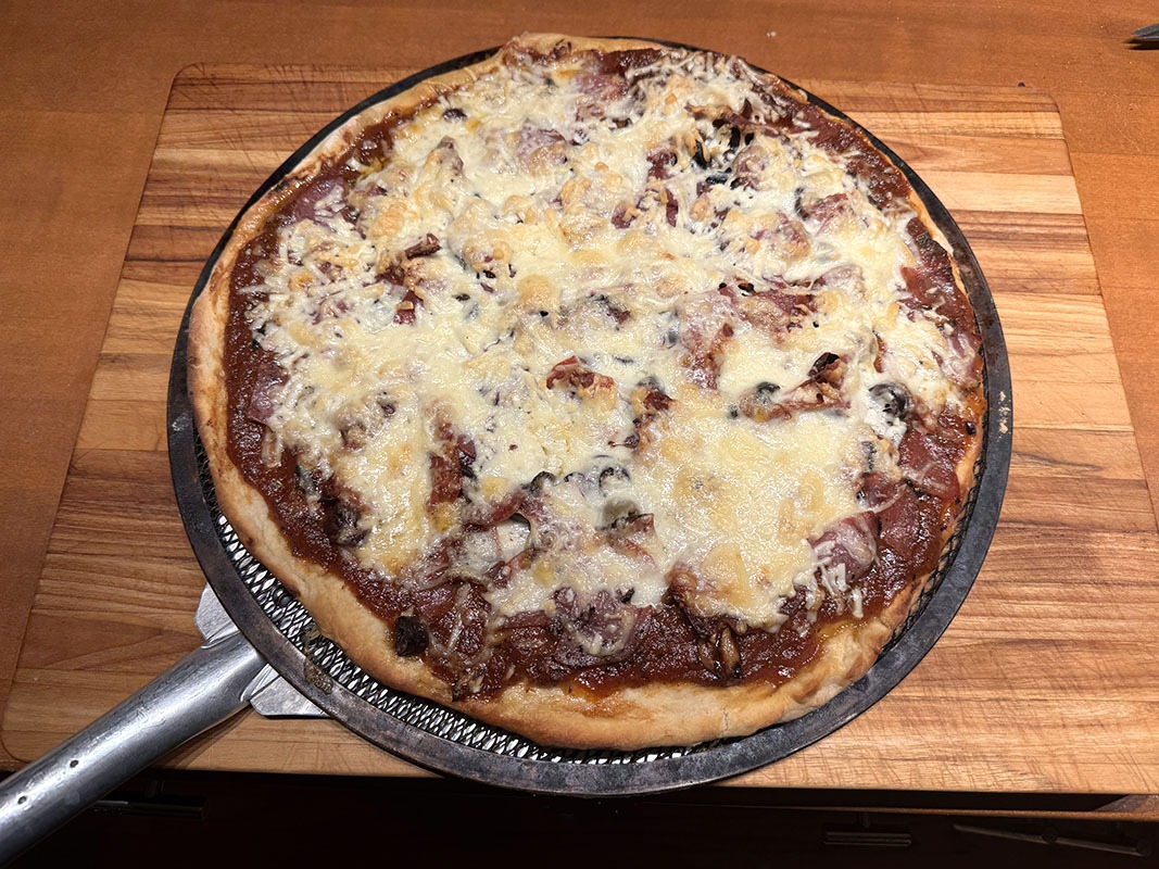 This pizza features three salamis, mushrooms, and olives.